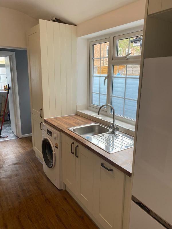 Cream utility room with sink and washing machine