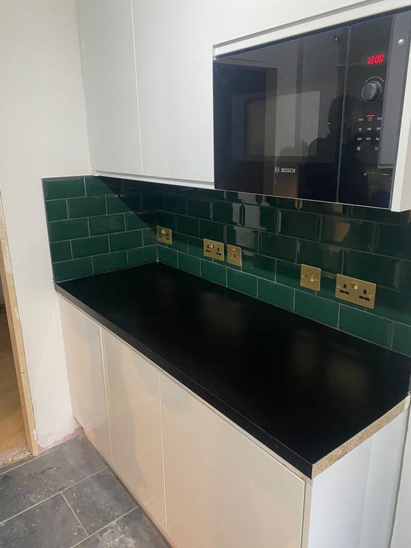 Modern kitchen with black counters and Bosch microwave